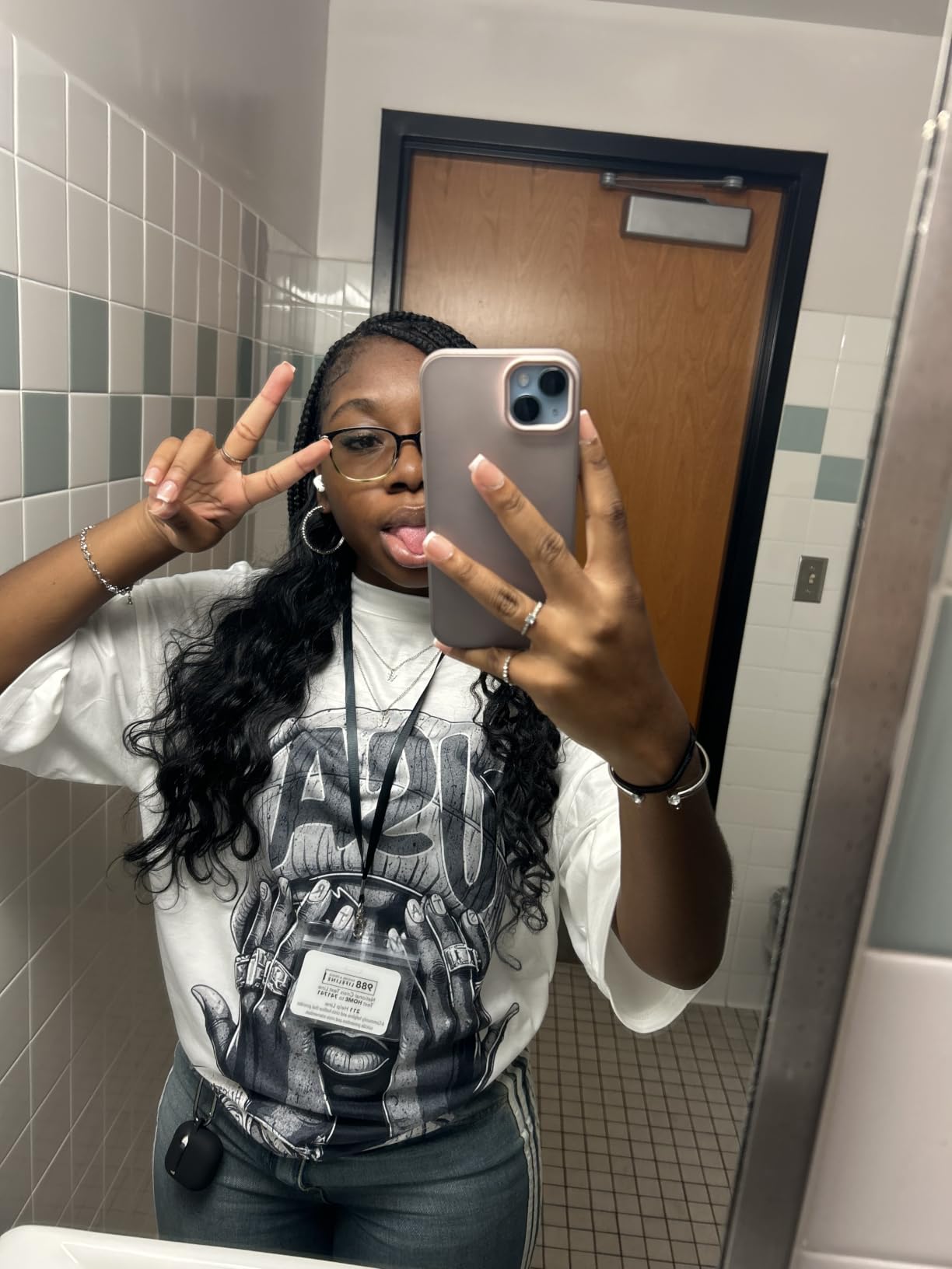 Customer wearing a long loose wave install falling past the waist, taken in a school bathroom mirror