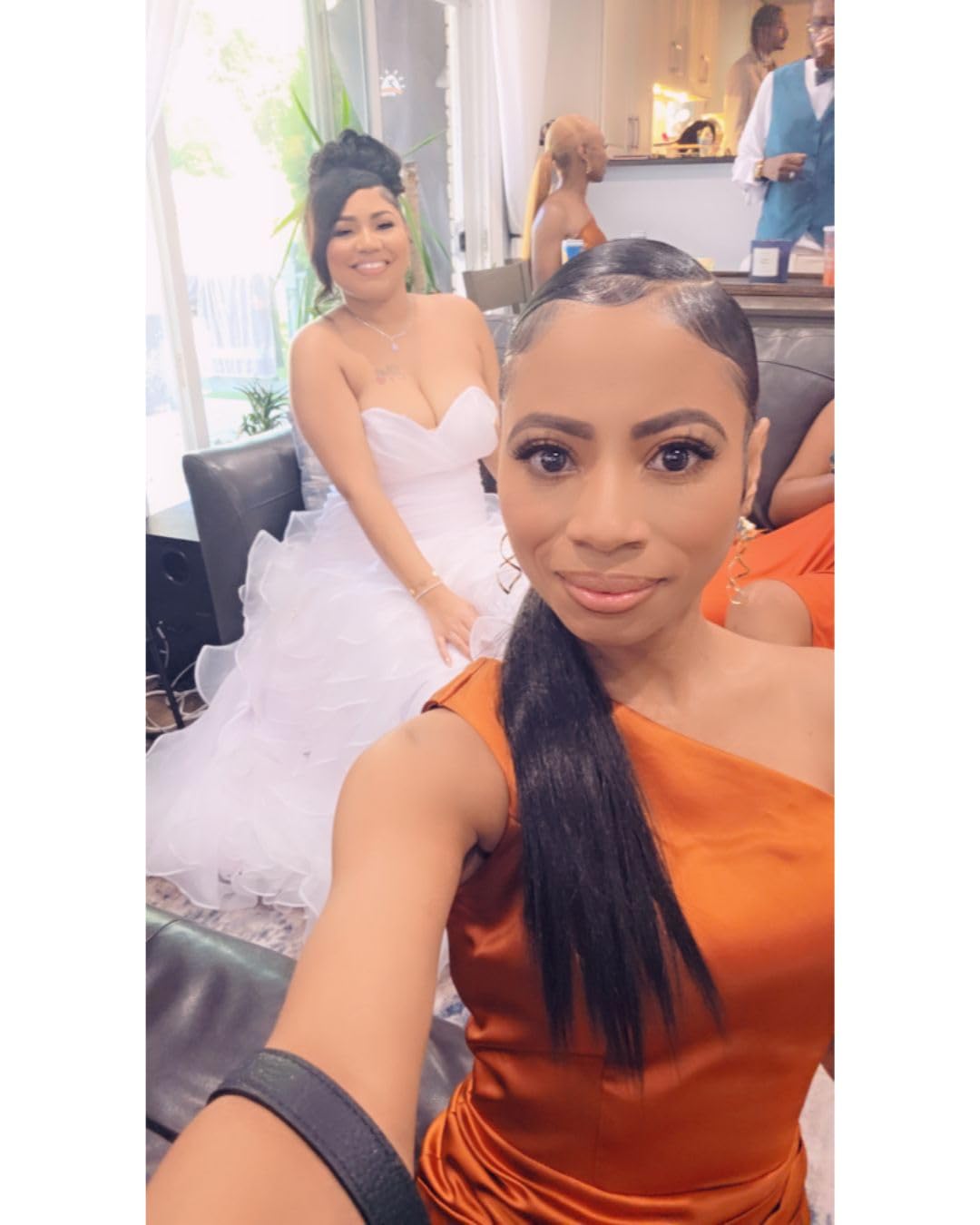 Sleek straight side ponytail worn at a wedding, laid flat at the crown with the length brought over one shoulder